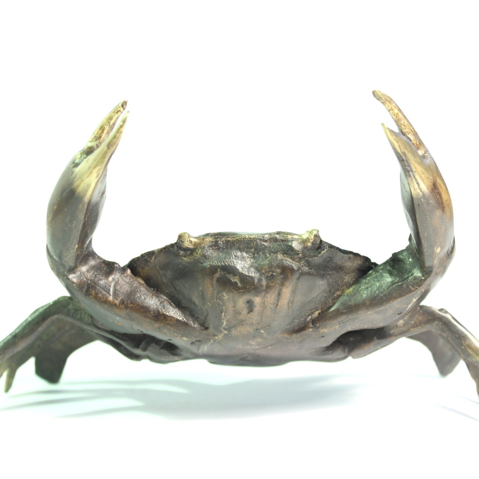 Front-facing view of hand-cast brass crab with both claws lifted upward