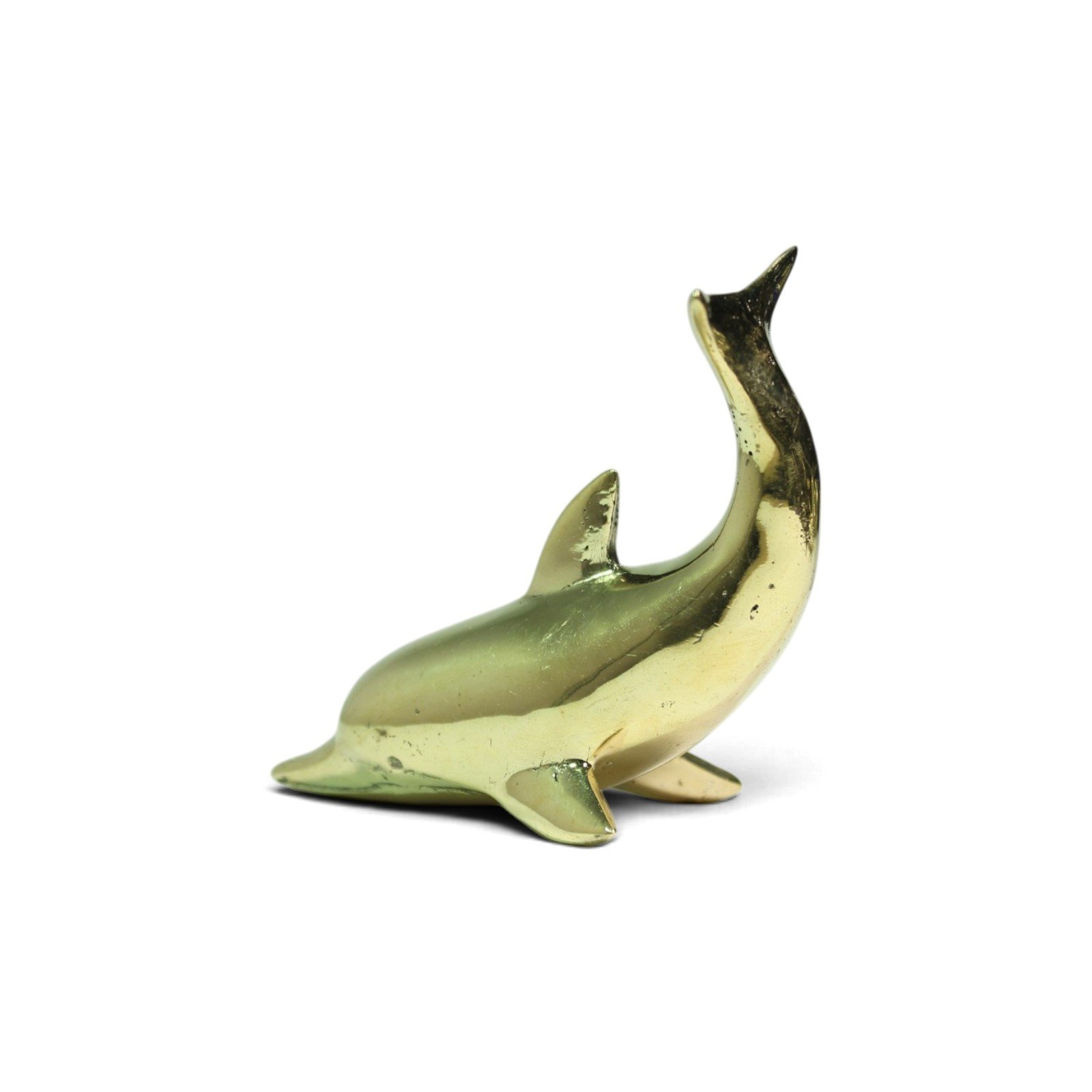 Brass dolphin figurine seen from behind with tail fin raised upward
