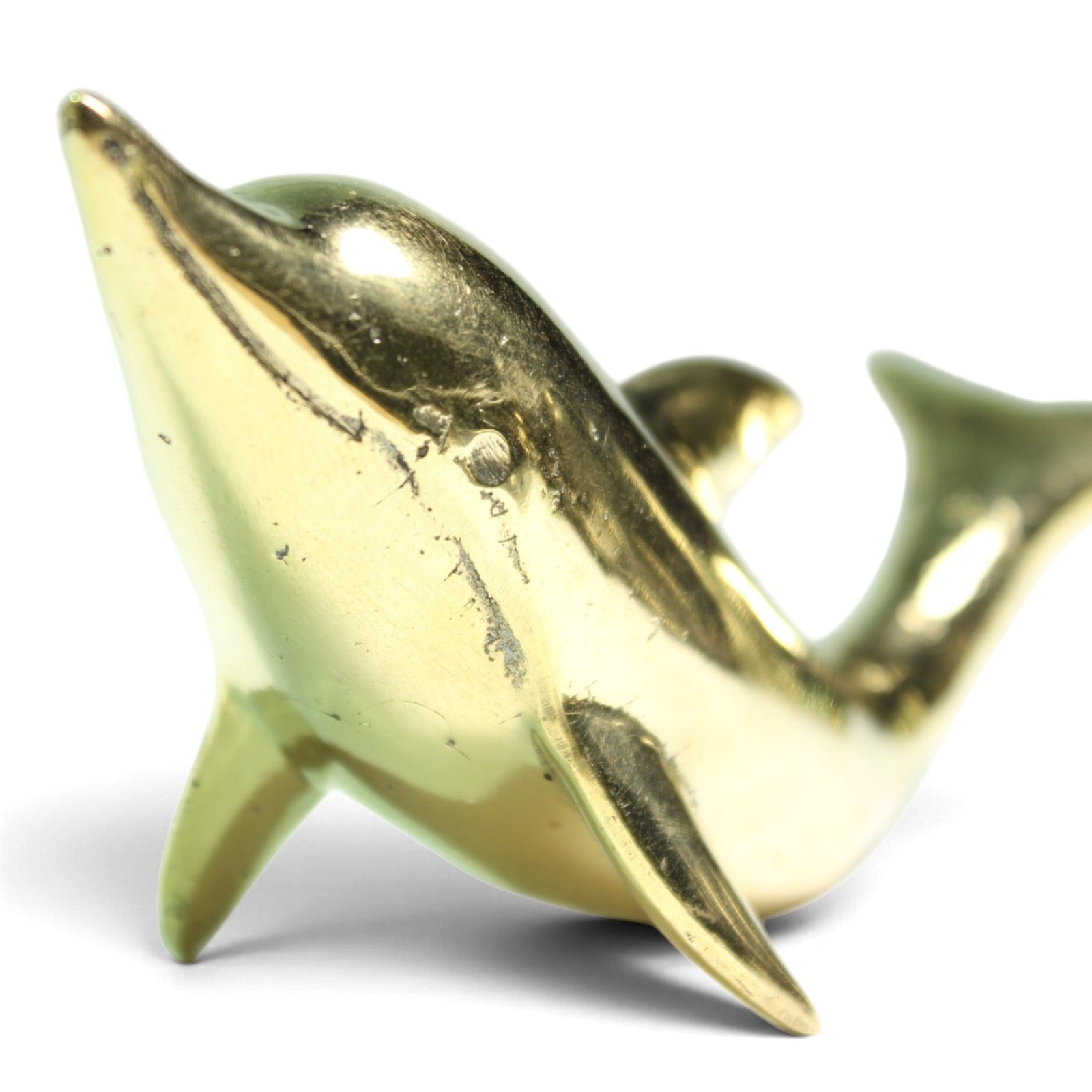 Close-up of the brass dolphin's fins showing hand-finishing texture