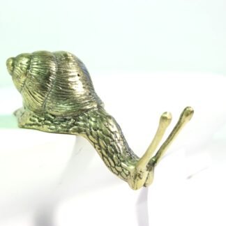 Brass laying snail figurine viewed from above showing textured shell and extended tentacles