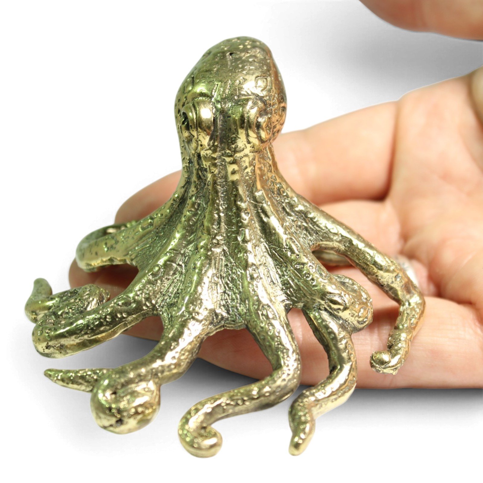 Brass octopus figurine held in an open palm to show its small handheld size