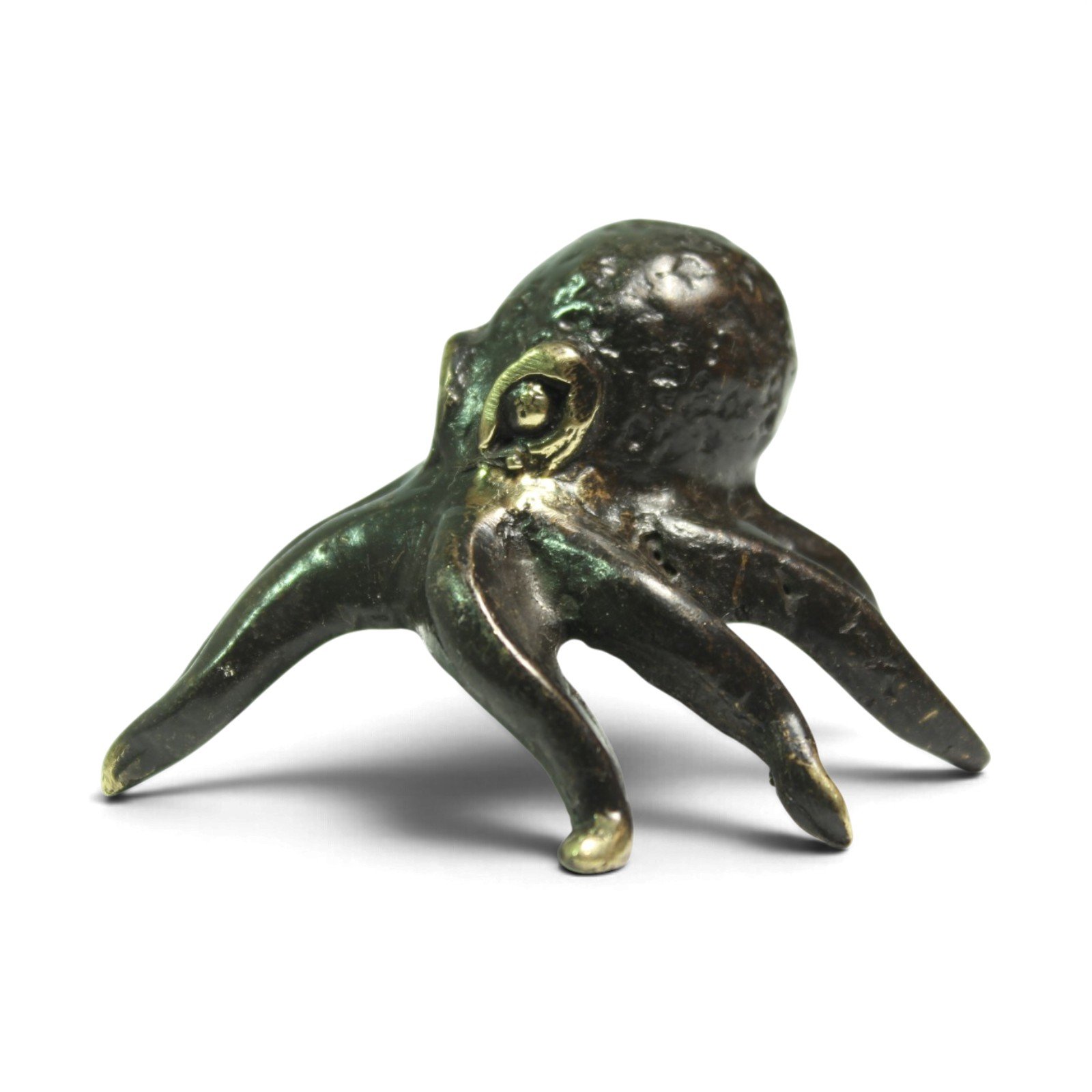Brass octopus figurine viewed from the side, showing curved leg shapes