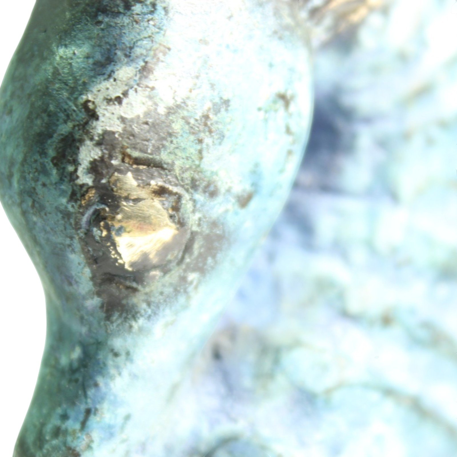 Macro shot of brass fin detail with gold brass showing through verdigris finish