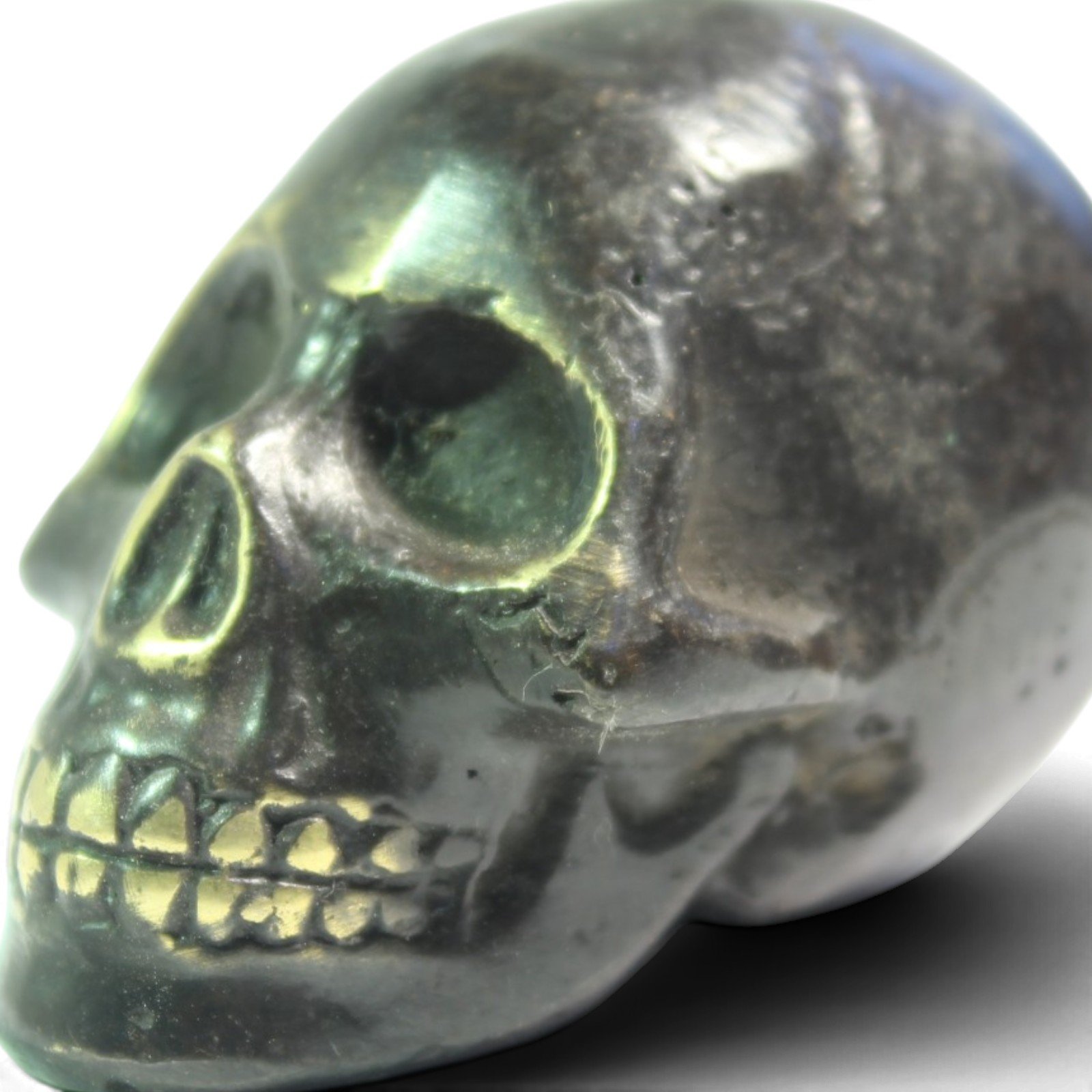 Close-up of the brass skull's eye socket showing casting texture and patina
