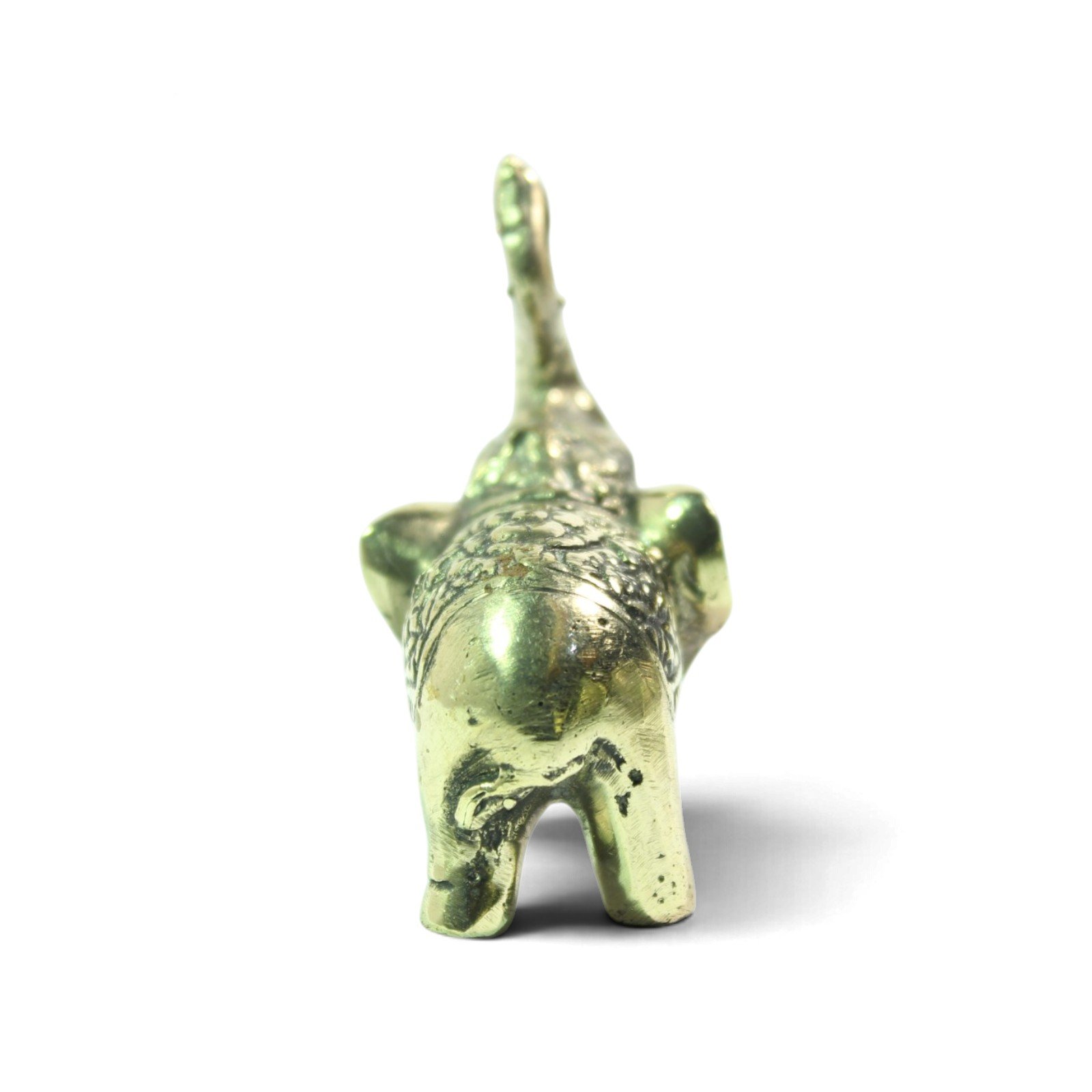 Rear view of brass elephant figurine showing tail and hind legs