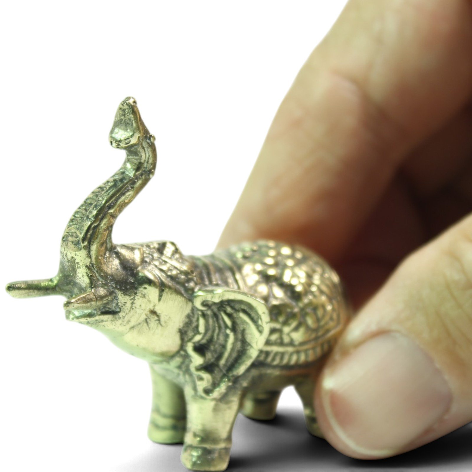 Brass elephant figurine held between fingers to show its small handheld size