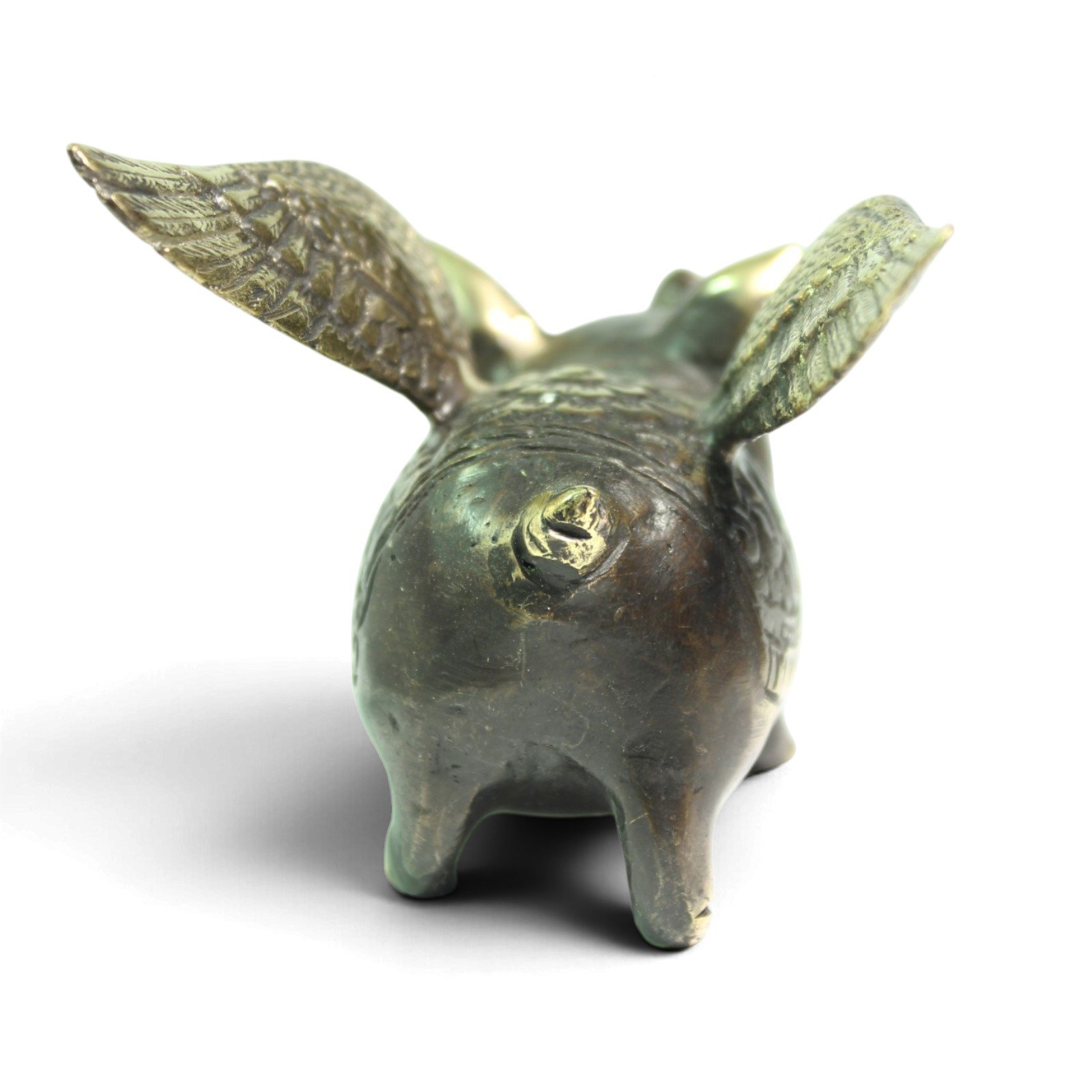 Rear view of brass pig figurine showing tail mark and spread wings