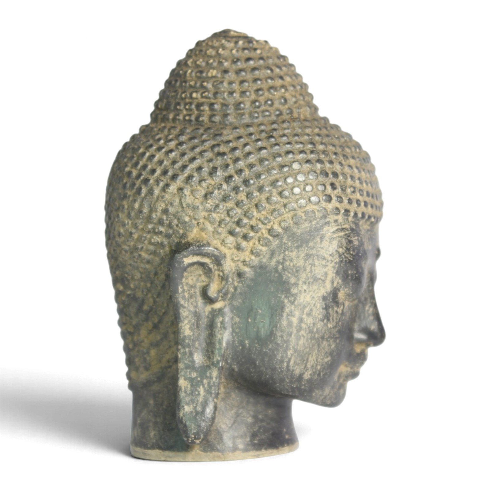 Side profile of the Buddha head showing curled topknot and ear detail