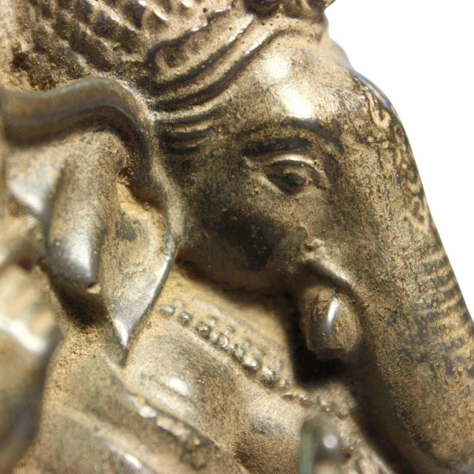 Close-up of Ganesha's face showing trunk, tusk, and finish texture
