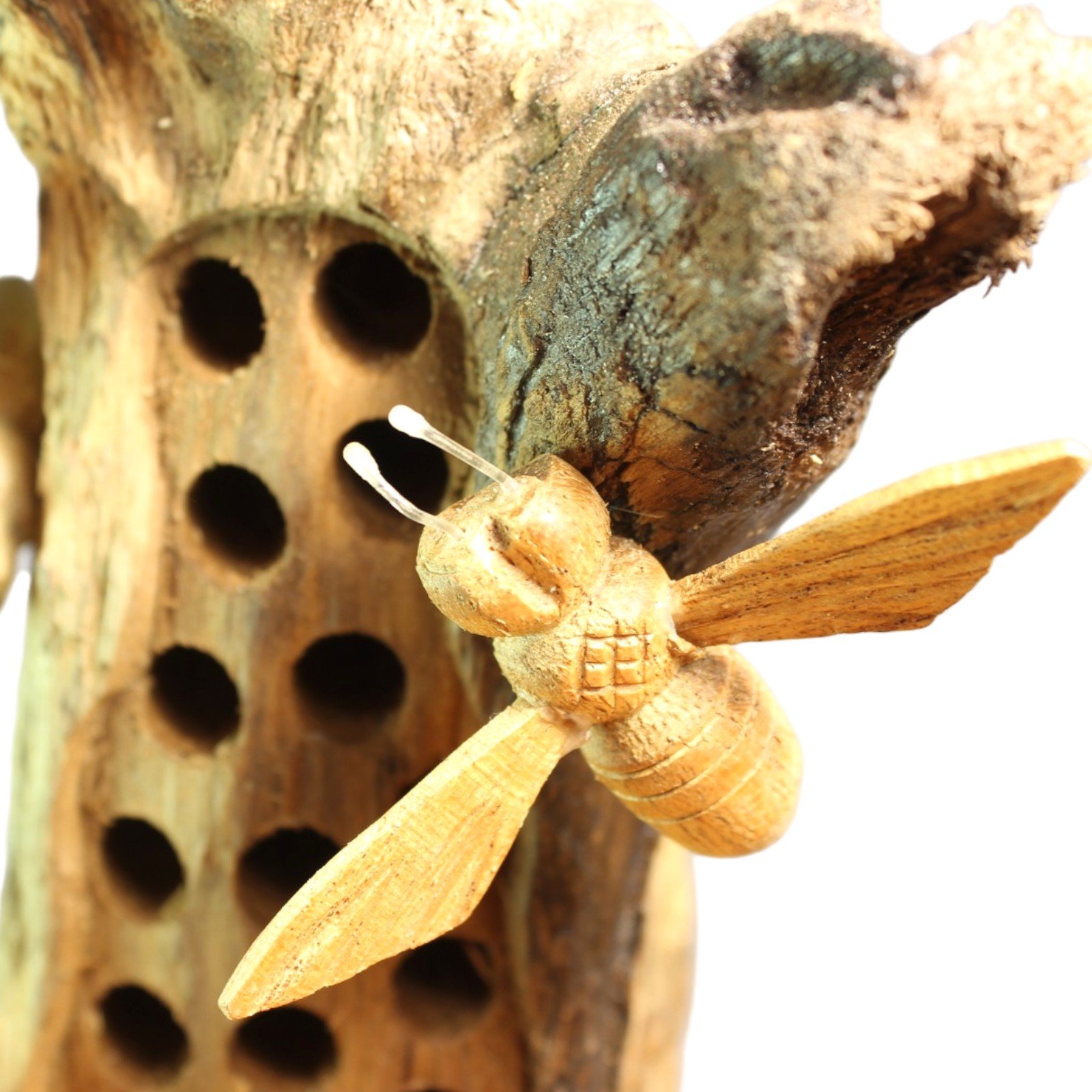 Macro shot of a carved bee's body and antennae beside the honeycomb holes