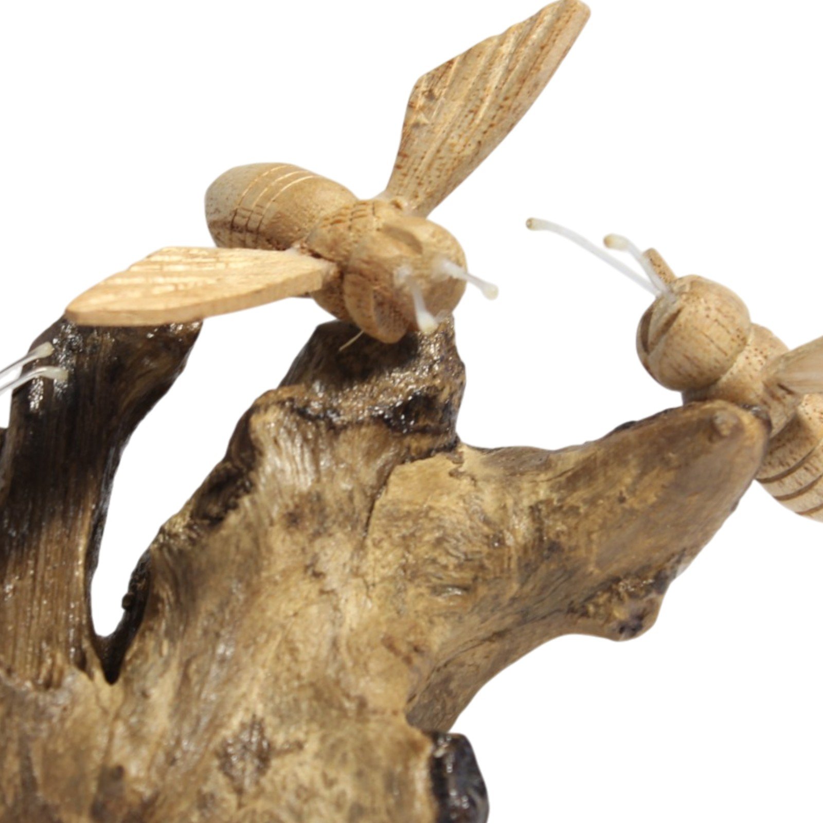 Close-up of two carved wooden bees with wire antennae on the wood base