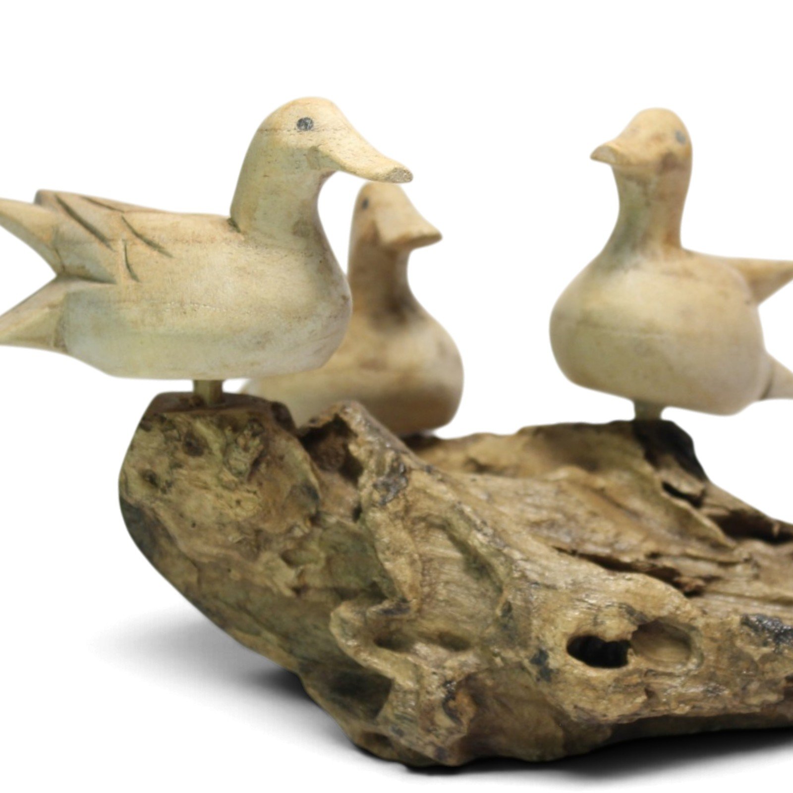 Close-up of the lead duck's carved wings and the textured parasite wood base beneath
