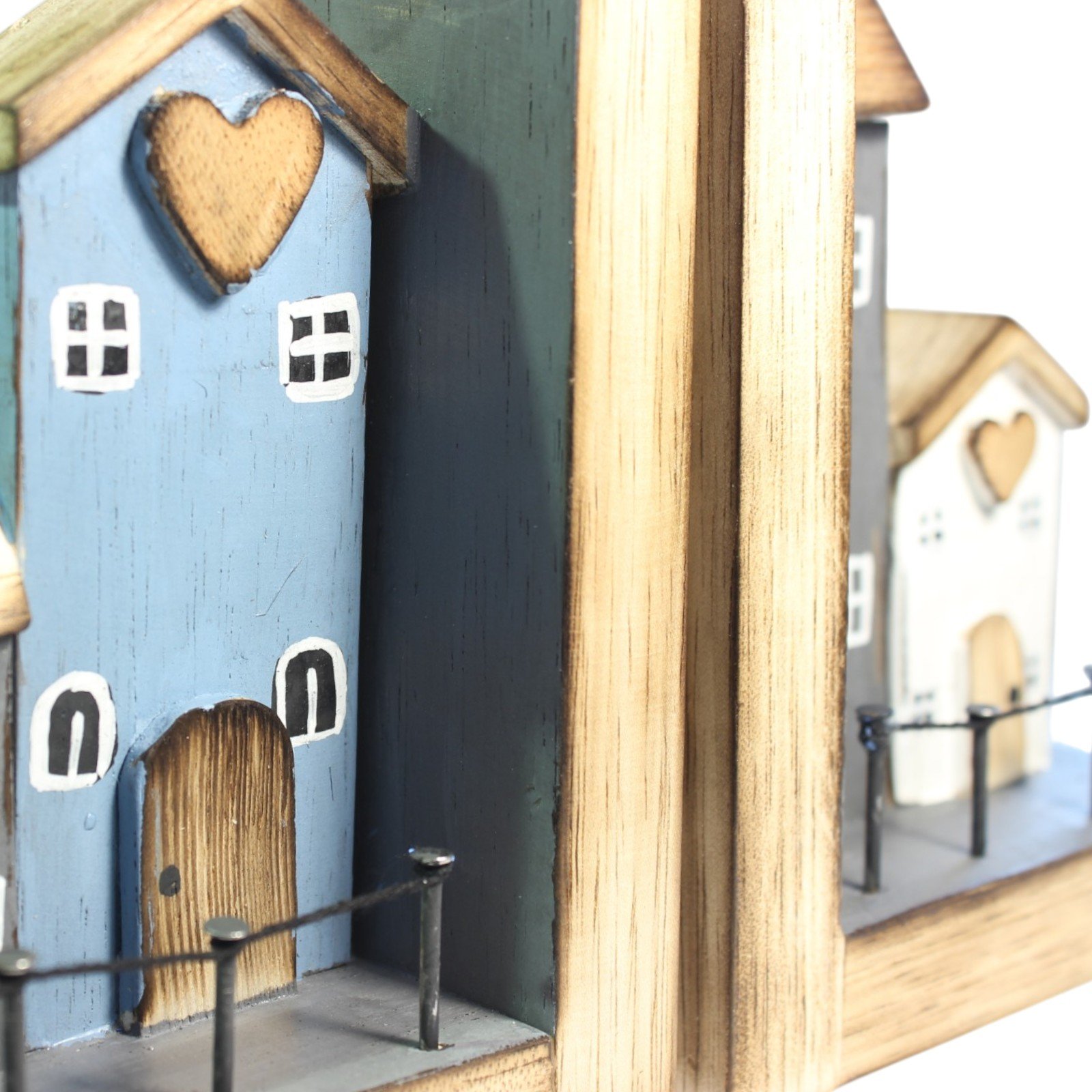 Close-up of the blue cottage's heart-shaped gable, painted windows and wooden door