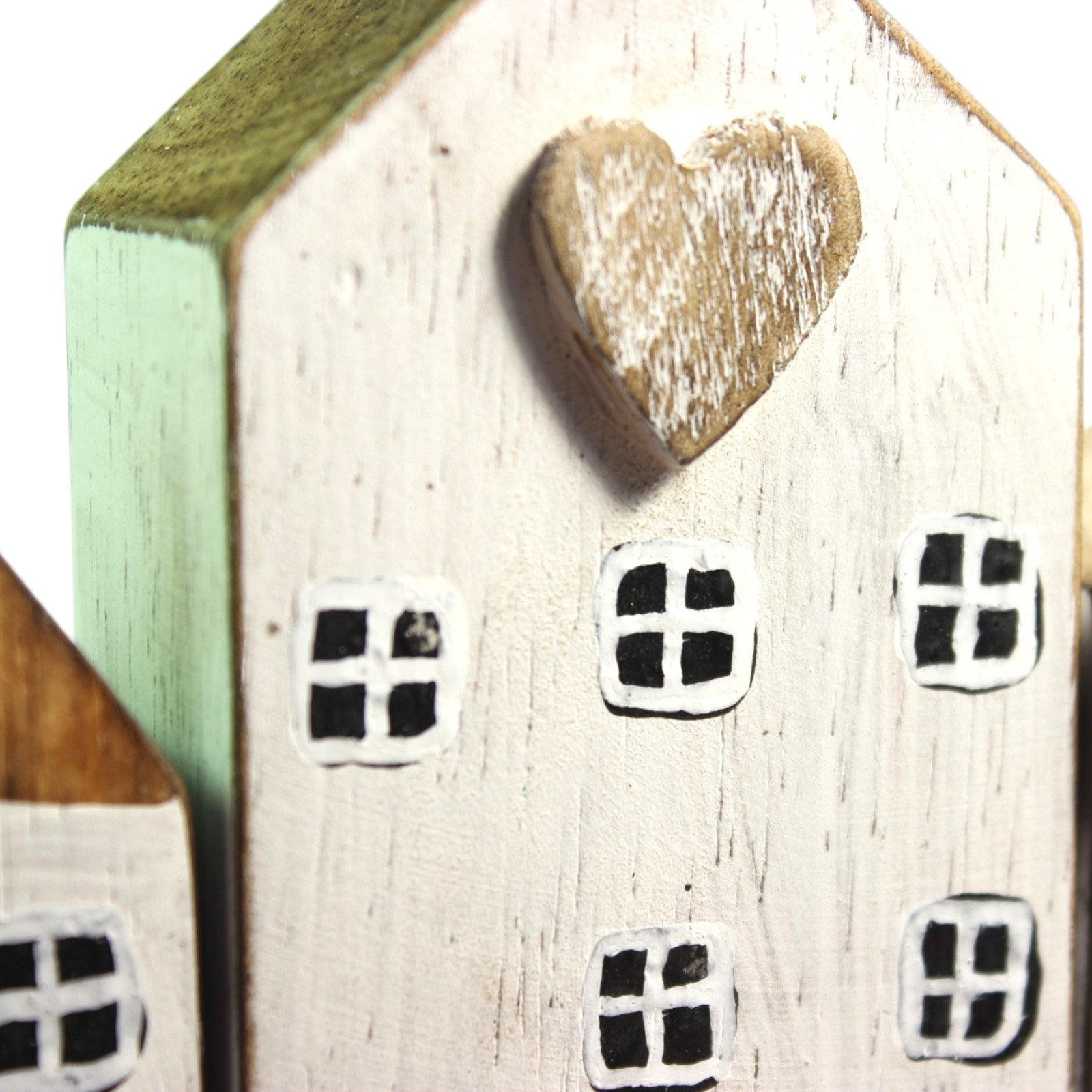 Close-up of a carved wooden heart detail set into the gable of the tallest house