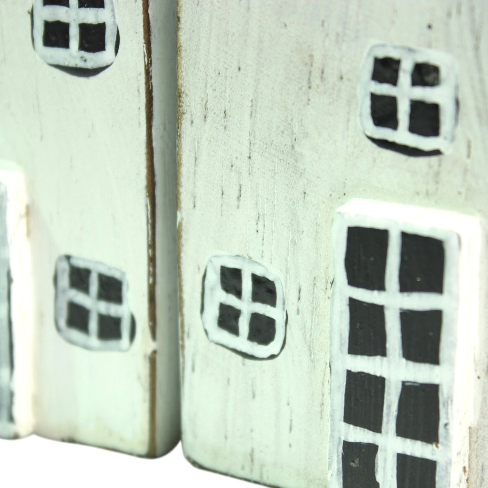 Close-up of hand-painted window and door details on two of the wooden houses