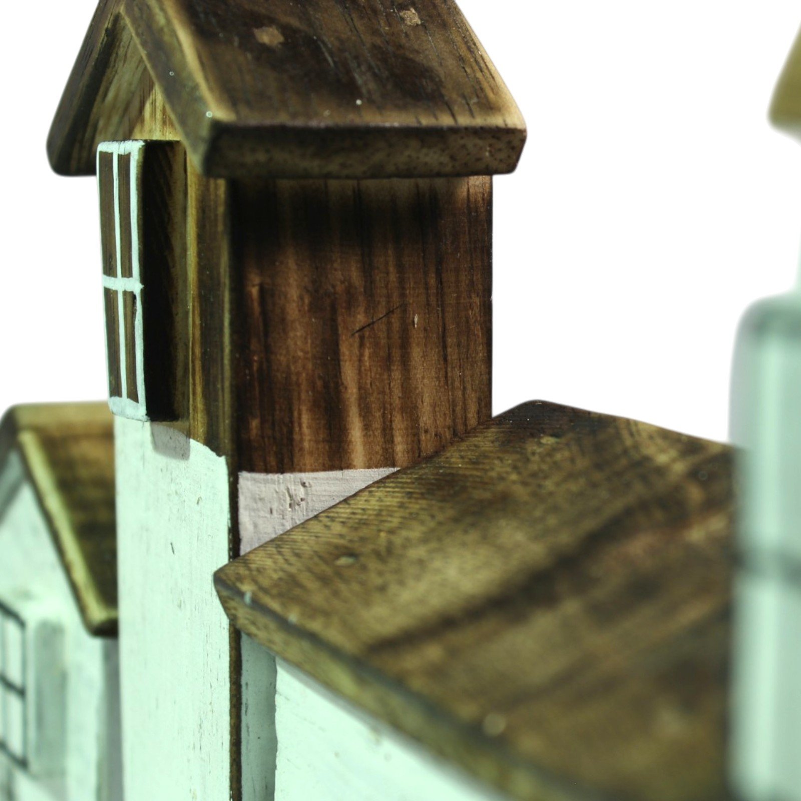 Close-up top view of a wooden house roof showing wood grain and hand-applied stain