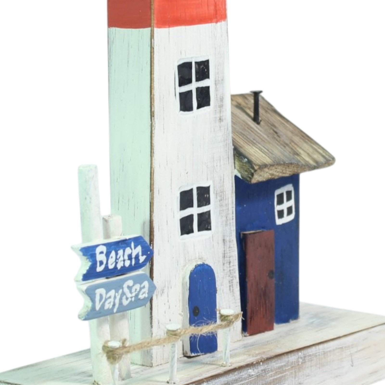 Close-up of the lighthouse windows, blue cottage door, and thatched-look roof detail
