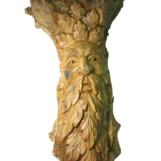 Side angle of the carved figure showing the leafy beard and torso detail