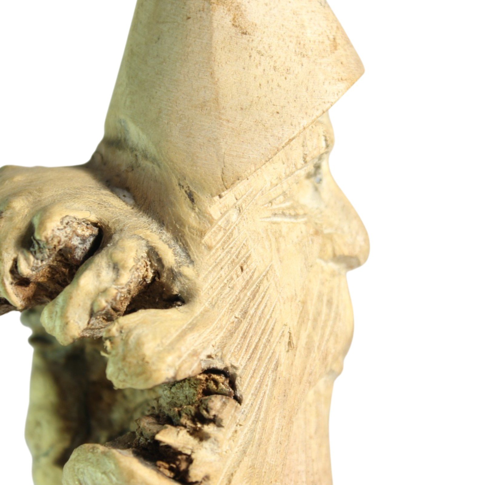 Close-up of the carved face beside the raw, textured parasite wood burl