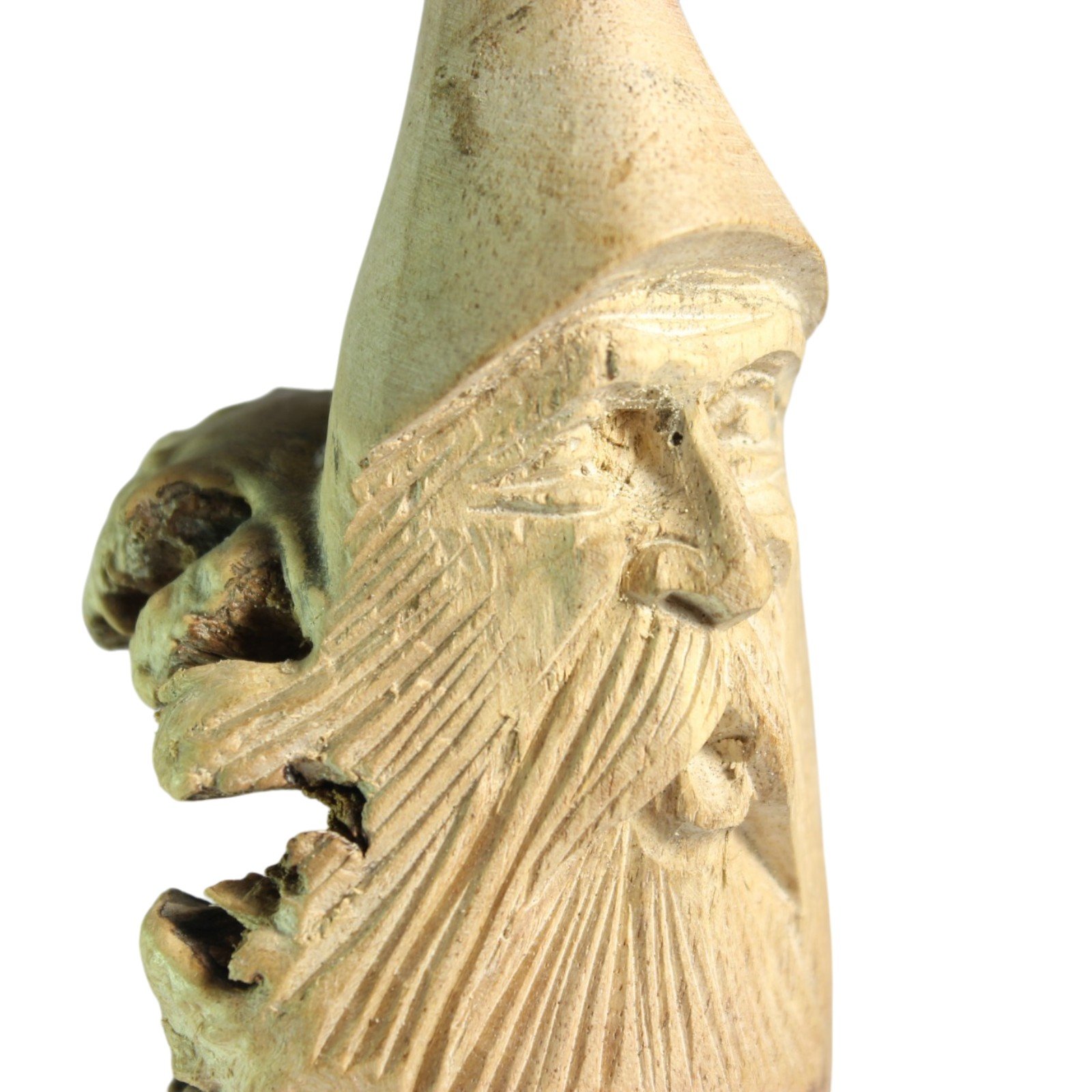 Side profile of the carved figure showing the pointed cap and layered faces
