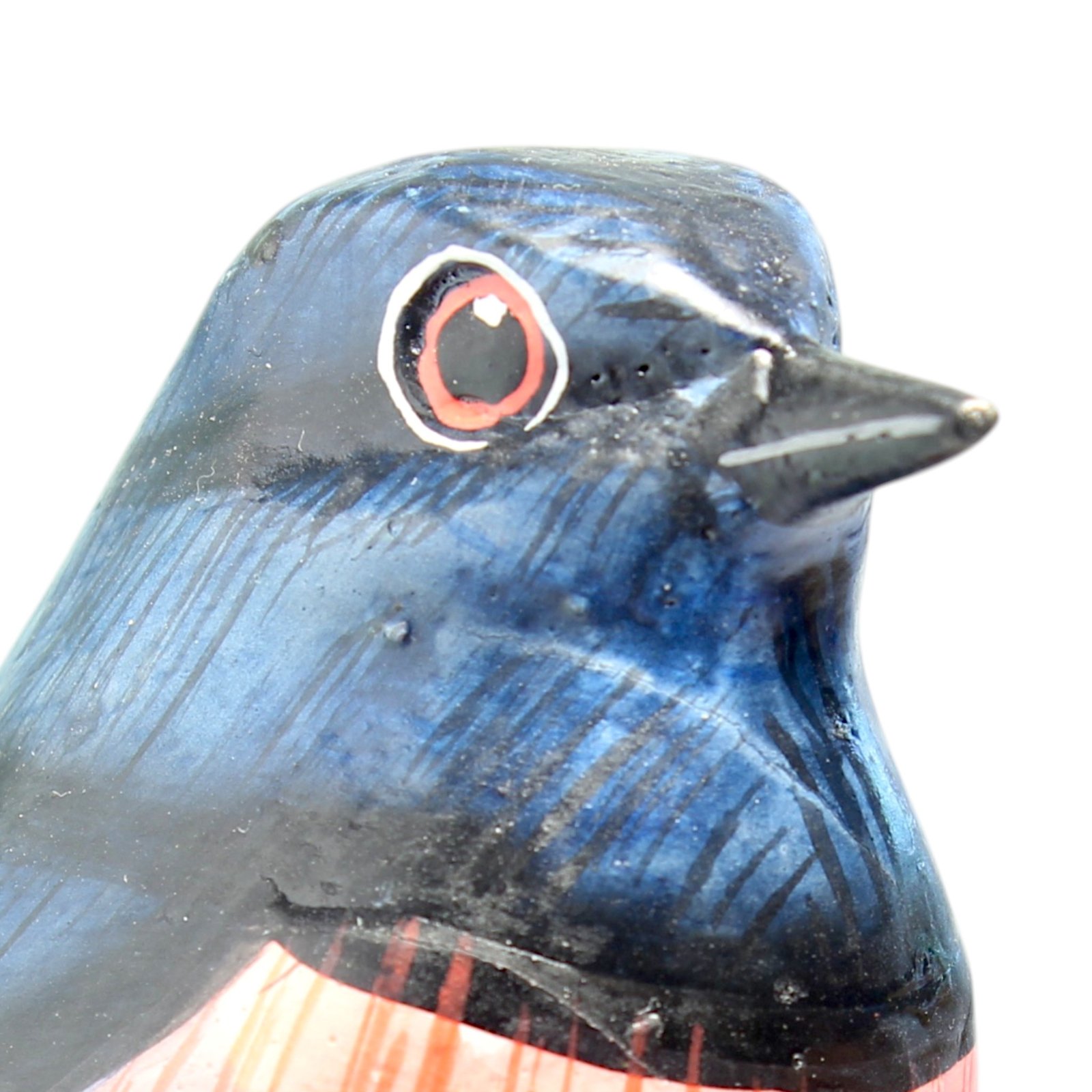Macro close-up of hand-painted eye on wooden bird figurine