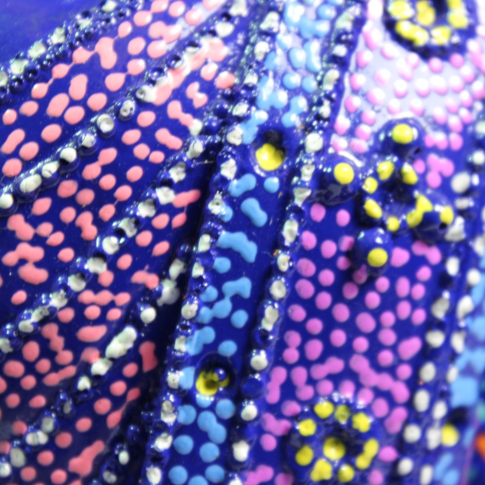 Macro shot of hand-painted dot pattern on the robe in pink, blue, and yellow