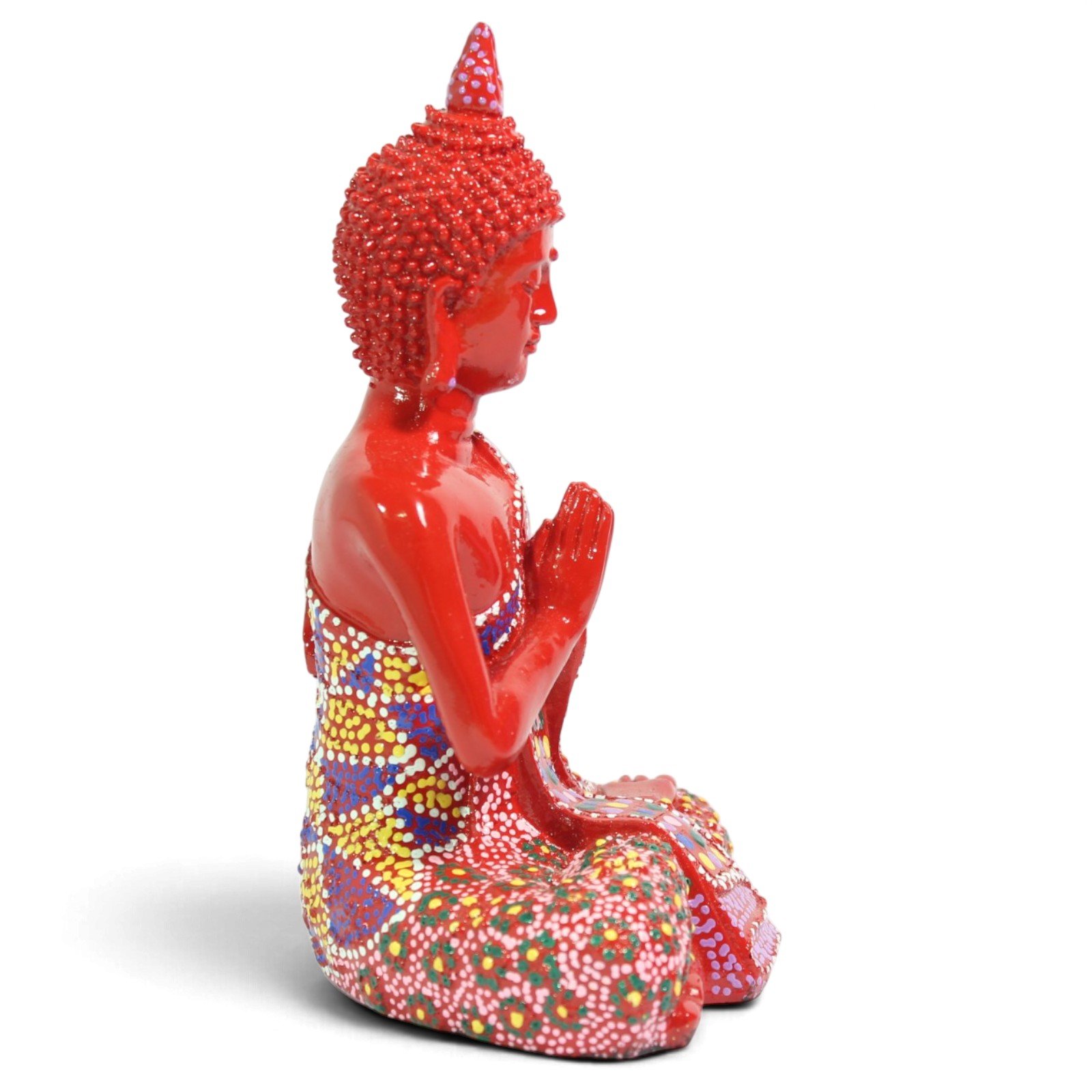Side profile view of the red Buddha figurine seated with hands together