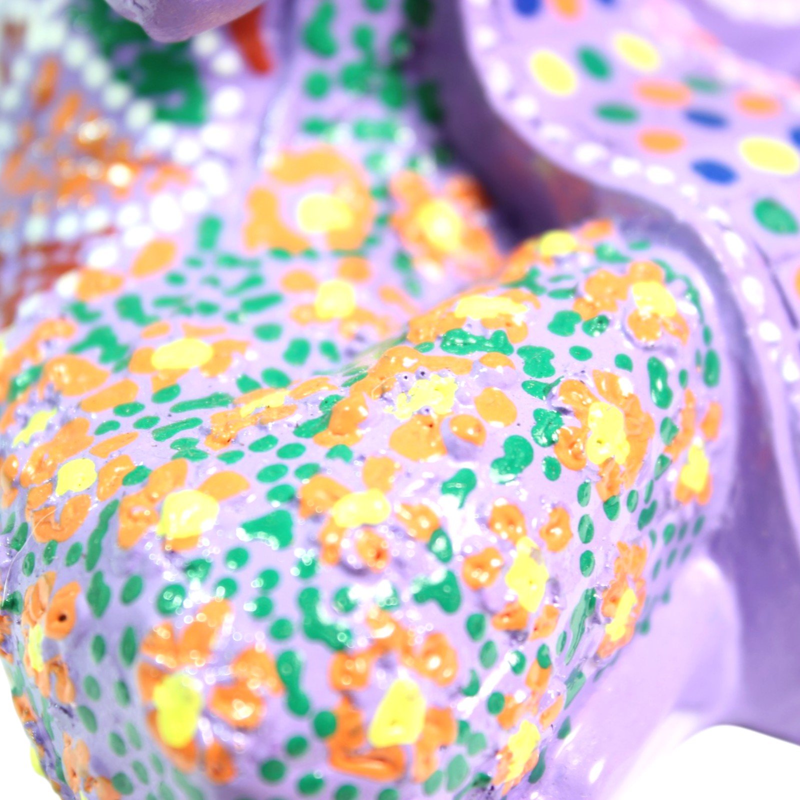Macro close-up of the hand-painted floral dot pattern on the base and robe