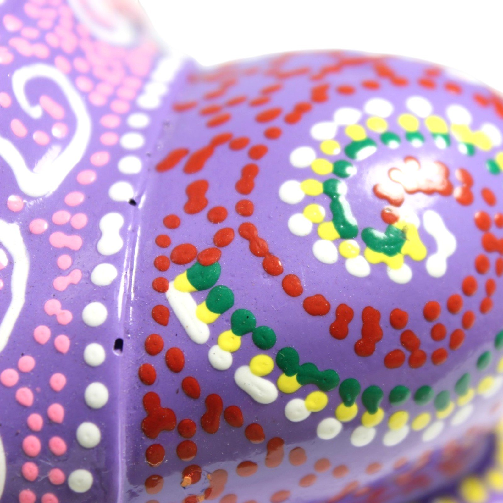 Macro close-up of colorful dot-work swirl pattern on the base of the figurine