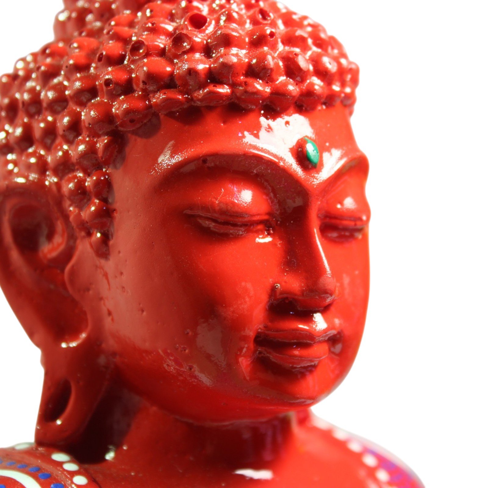 Close-up of the Buddha's serene painted face with green urna mark between the brows