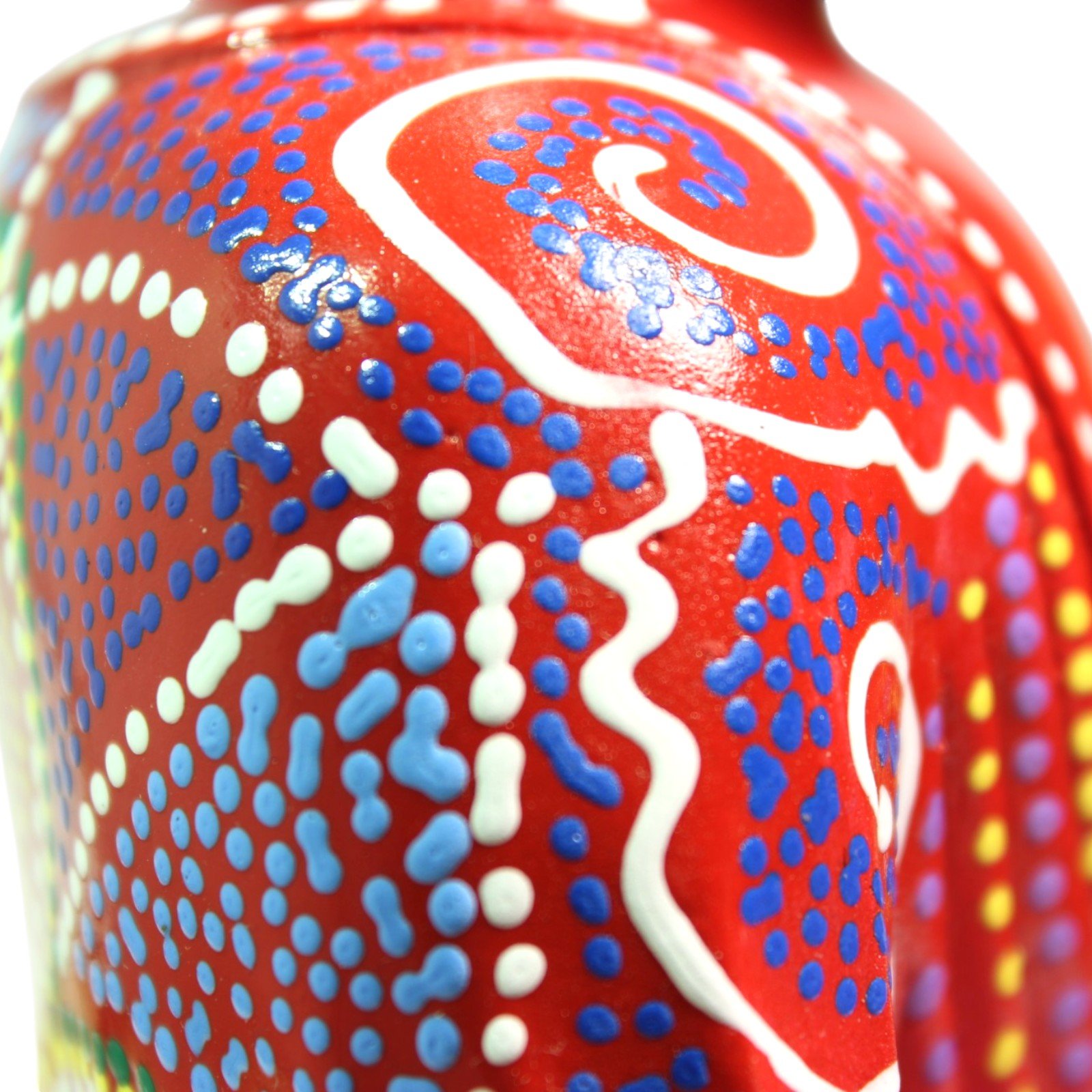Macro close-up of the hand-painted dot pattern in blue, yellow, and white on red resin