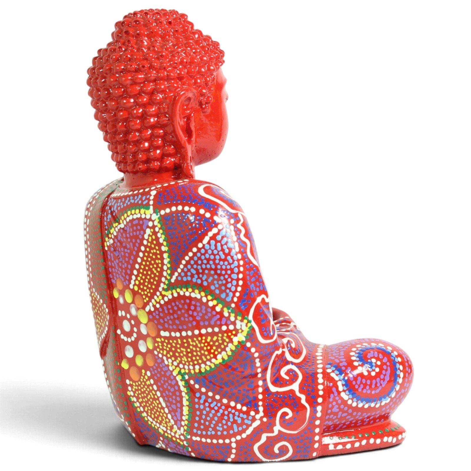 Side profile view of the red seated Buddha figurine highlighting its calm posture