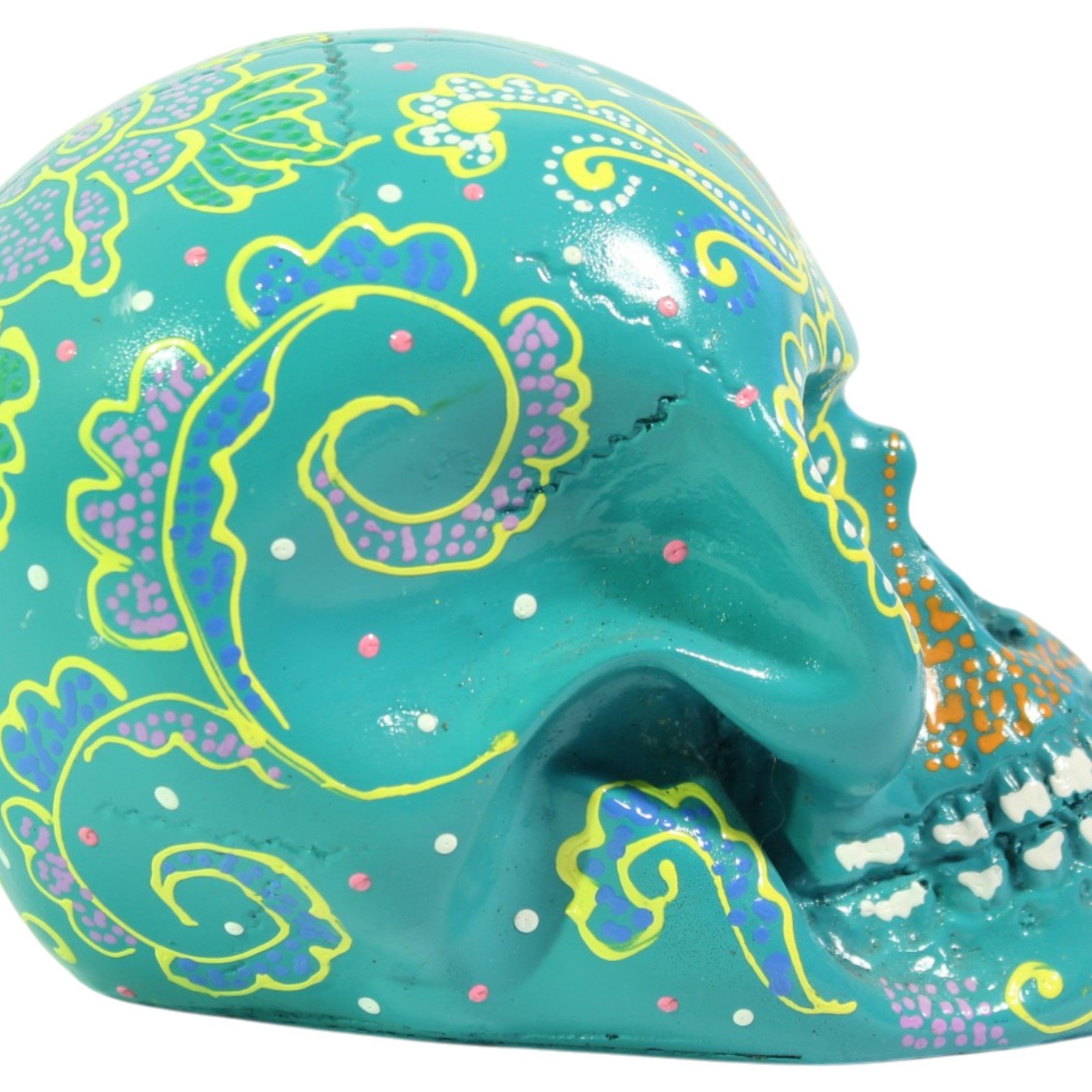 Side profile view of the teal skull showing painted spiral motif