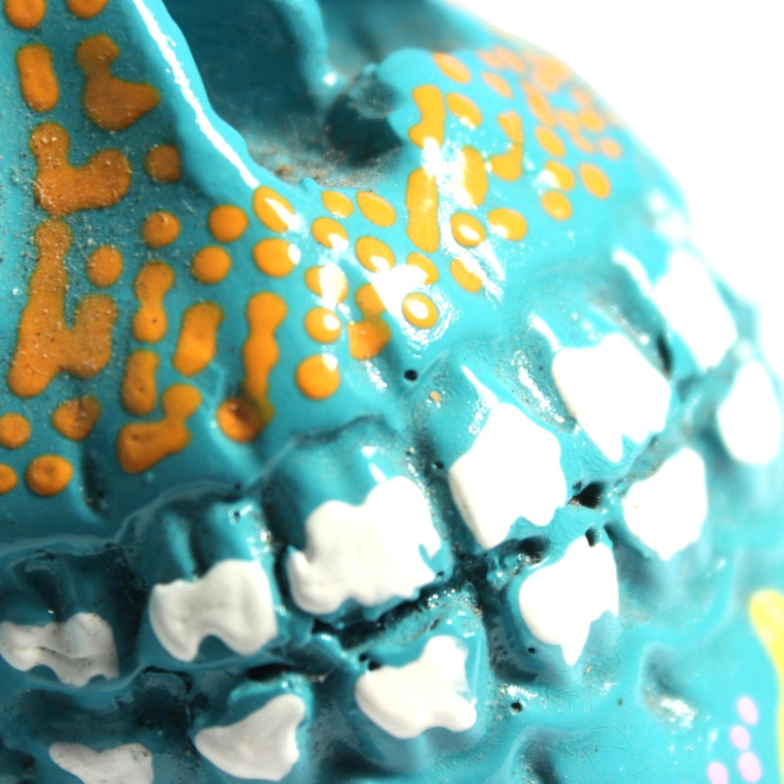 Extreme close-up of textured resin surface with painted teeth and dot pattern