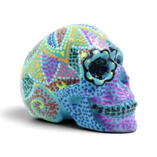 Three-quarter angle view of the painted skull showing vivid multicolor dot patterns across the side and top
