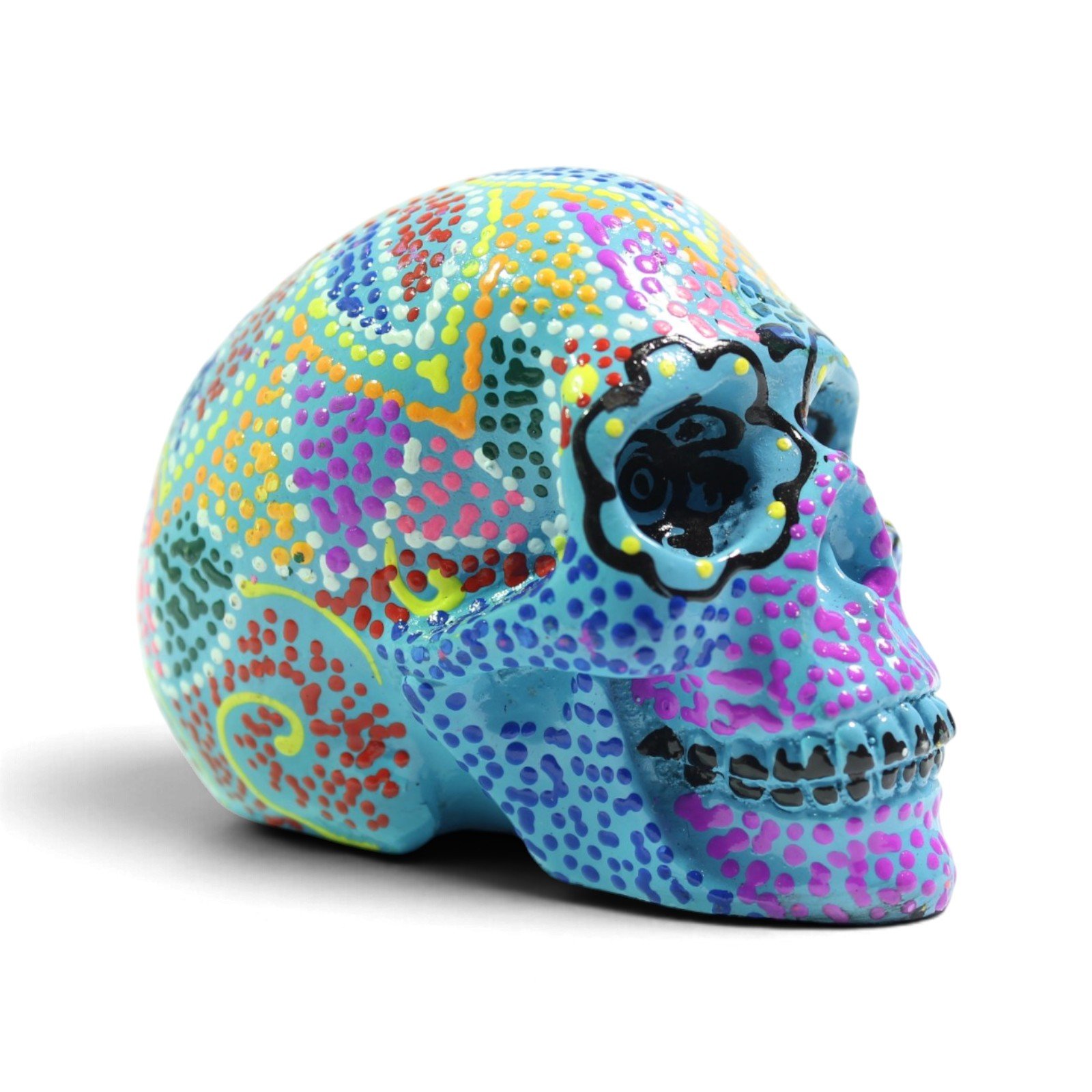 Three-quarter angle view of the painted skull showing vivid multicolor dot patterns across the side and top