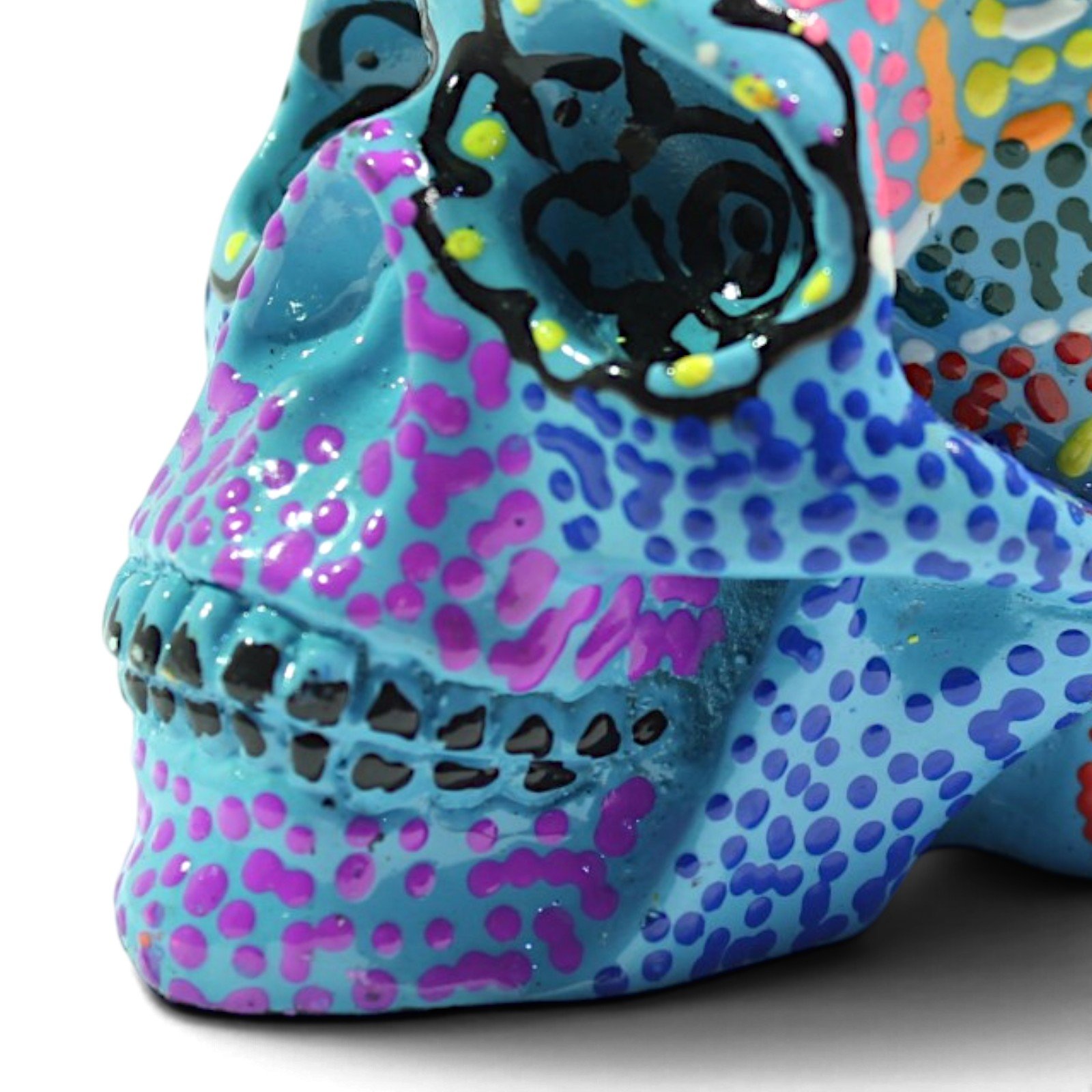 Close-up of the aqua skull's painted eye socket showing intricate black swirl detail and dotted texture