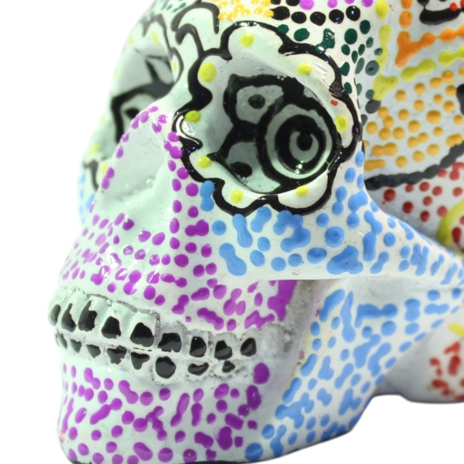 Close-up of skull's painted eye socket with black scrollwork and colorful dot patterns