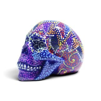 Side view of a dark blue resin skull figurine covered in colorful hand-painted dot patterns