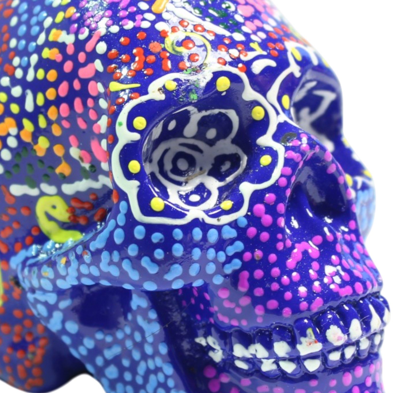 Close-up of painted texture showing layered dots in orange, blue, and yellow on dark blue base