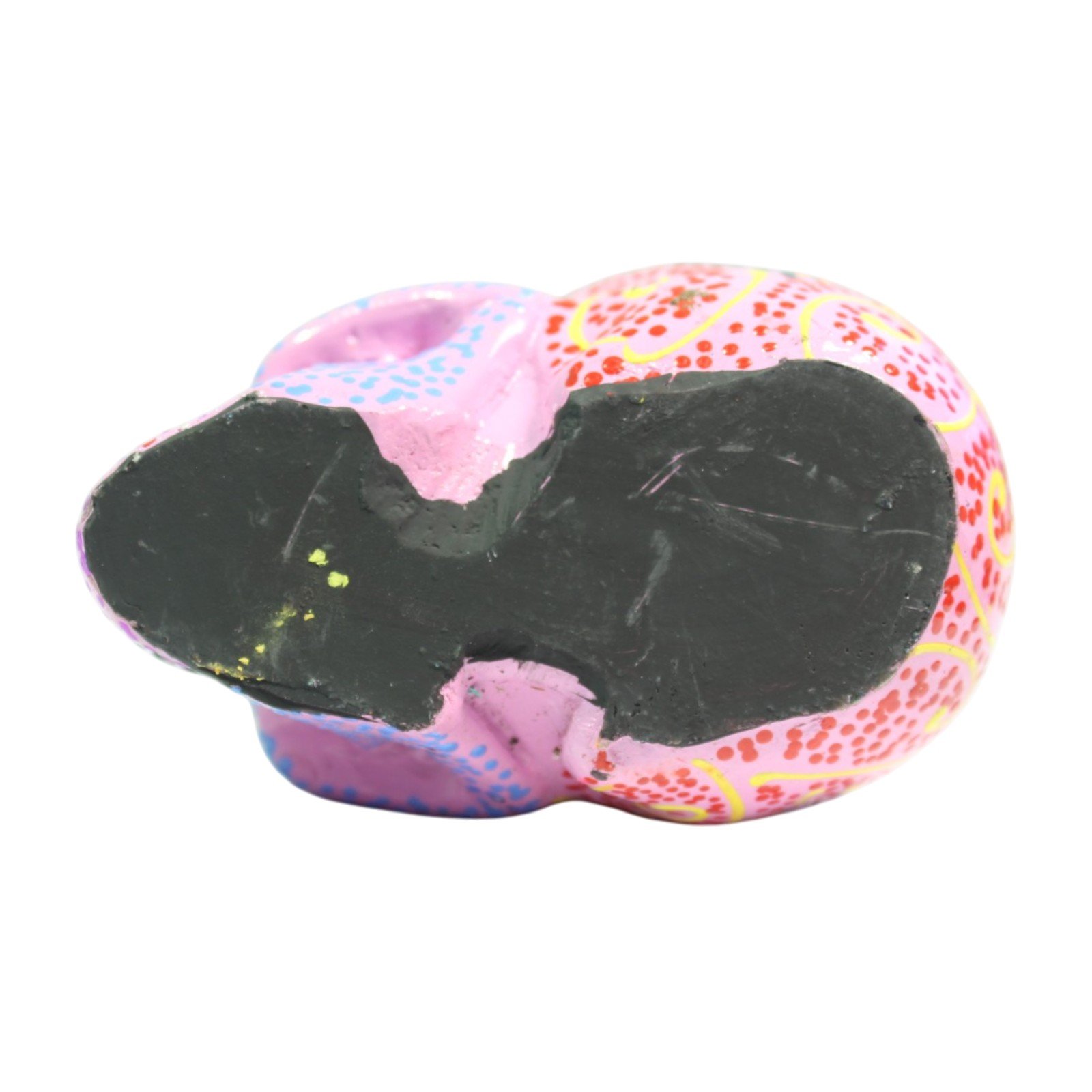 Bottom view of the skull figurine showing the flat unpainted base