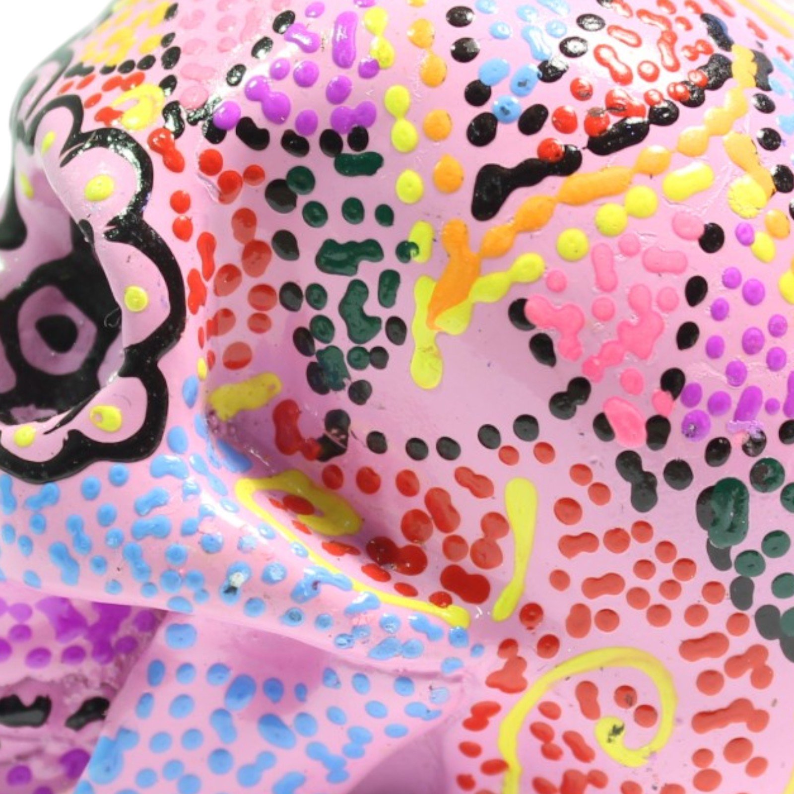 Macro shot of colorful dot patterns painted across the skull's cheekbone area