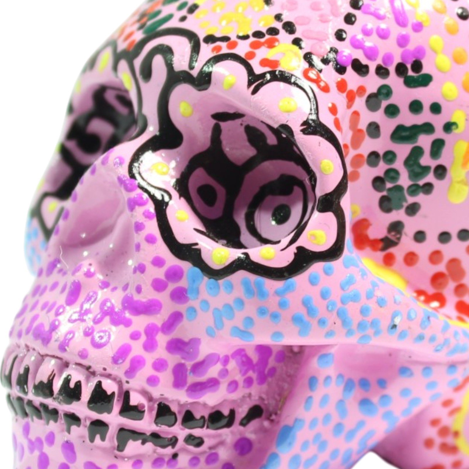 Close-up of the skull's eye socket showing black scrollwork outline and dotted paint detail