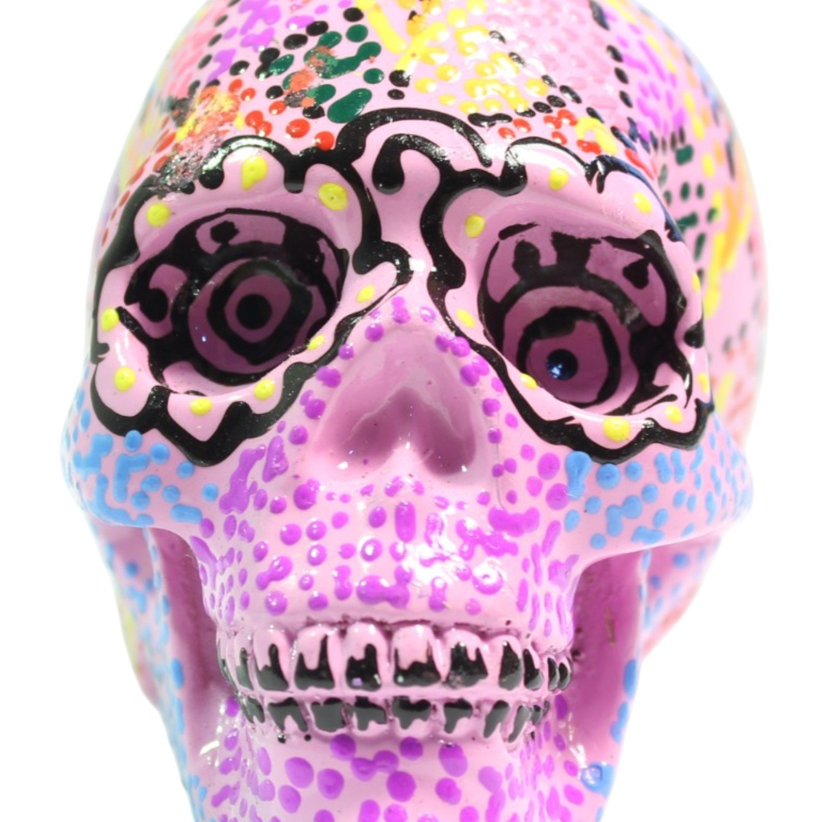 Front view of the pink skull figurine with painted eyes, nose, and teeth