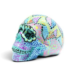 Turquoise resin skull figurine with colorful hand-painted dot patterns, three-quarter view