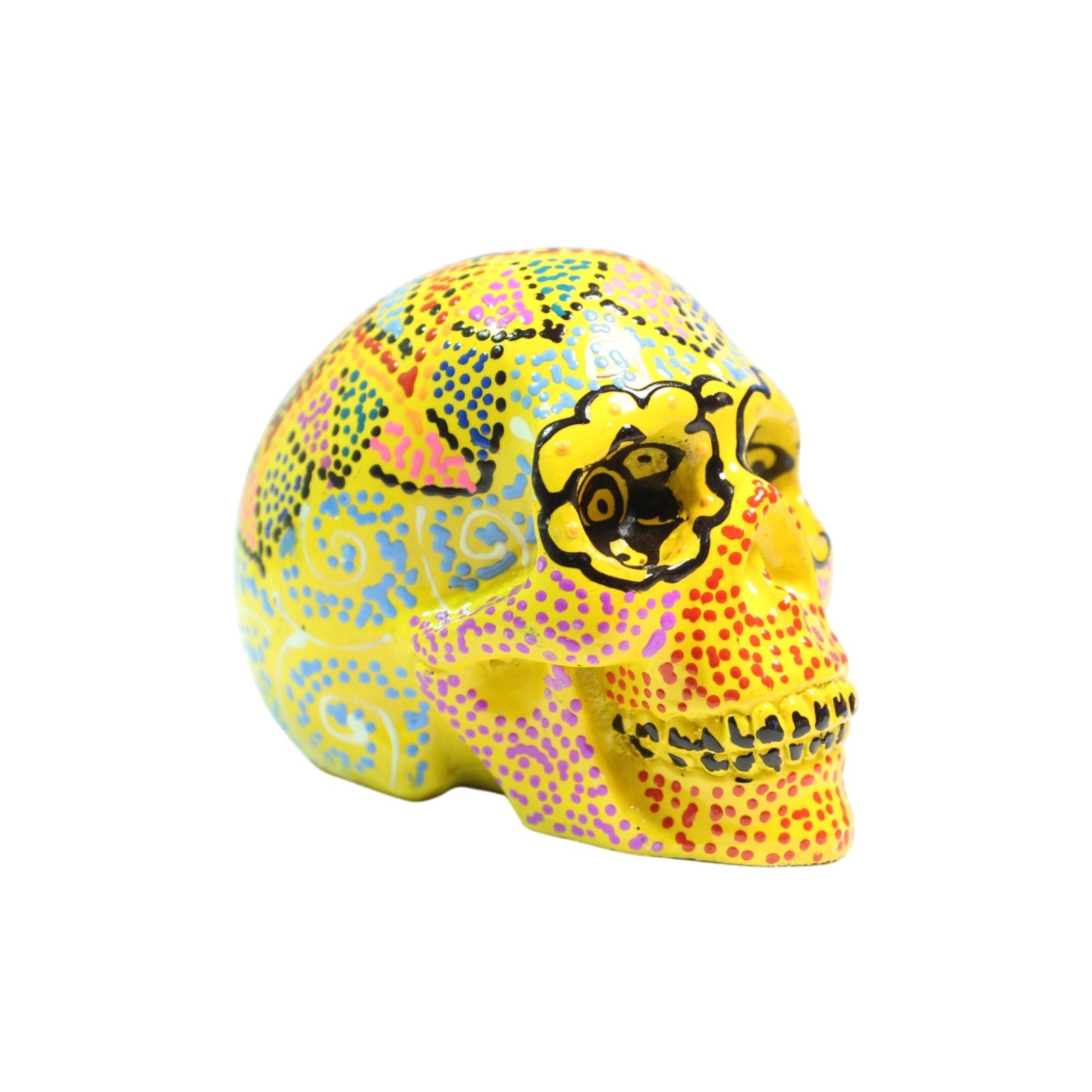 Three-quarter angle view of yellow skull figurine with colorful painted patterns