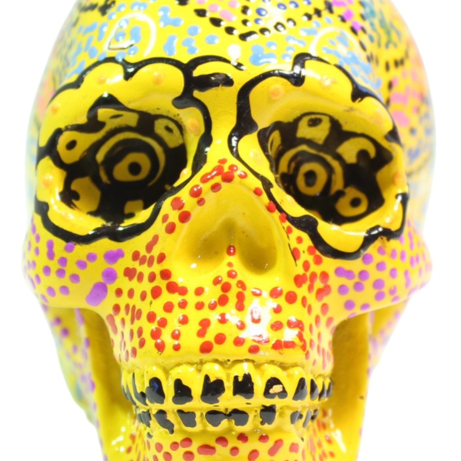 Front view of yellow resin skull showing painted eyes, nose, and teeth