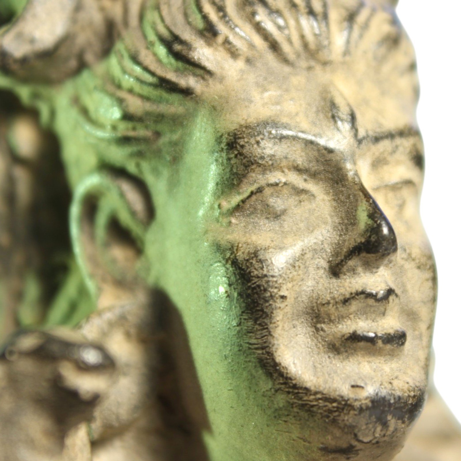 Extreme close-up of Shiva statue's face showing hand-applied patina variation