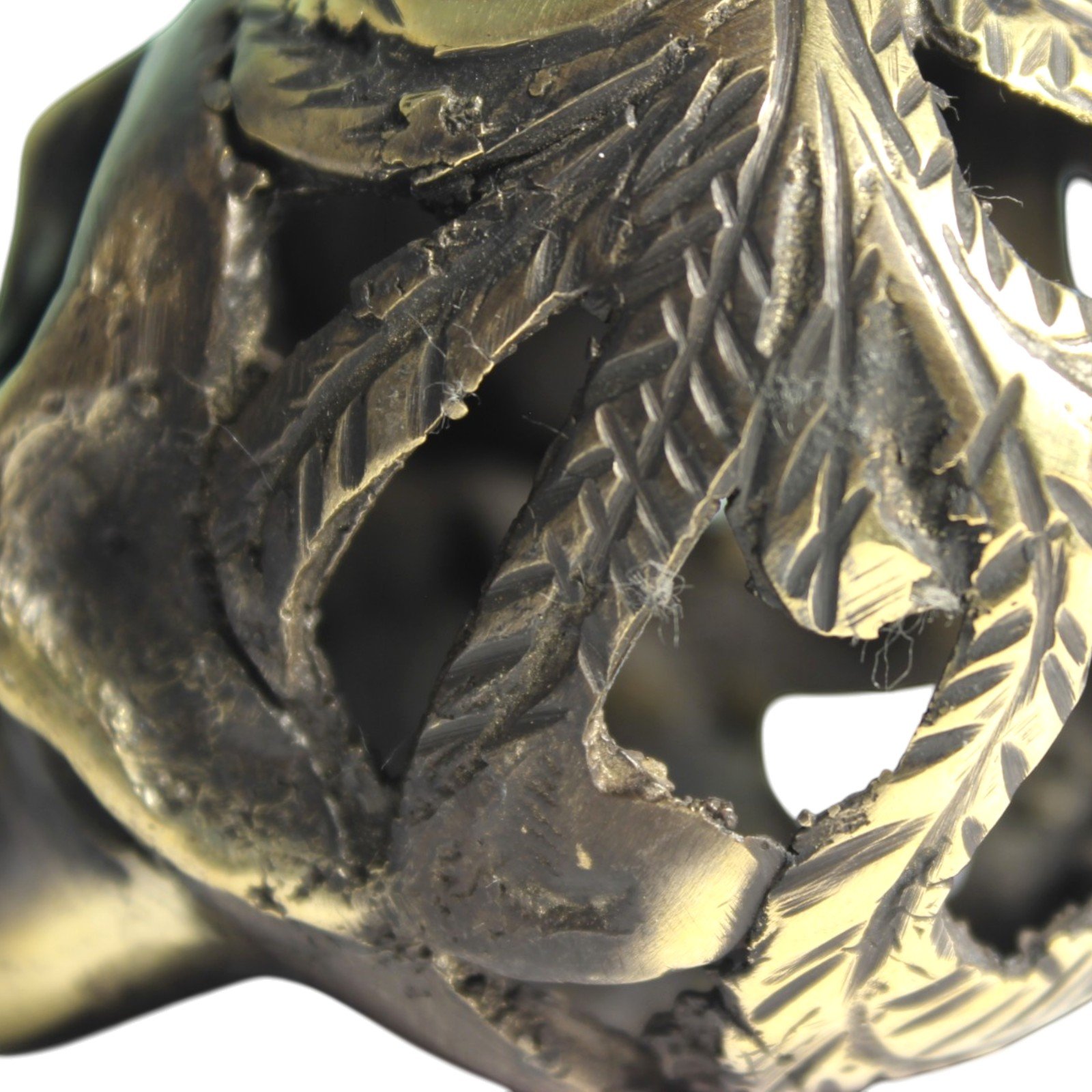 Handvara view of the brass skull figurine showing symmetrical carving and aged finish