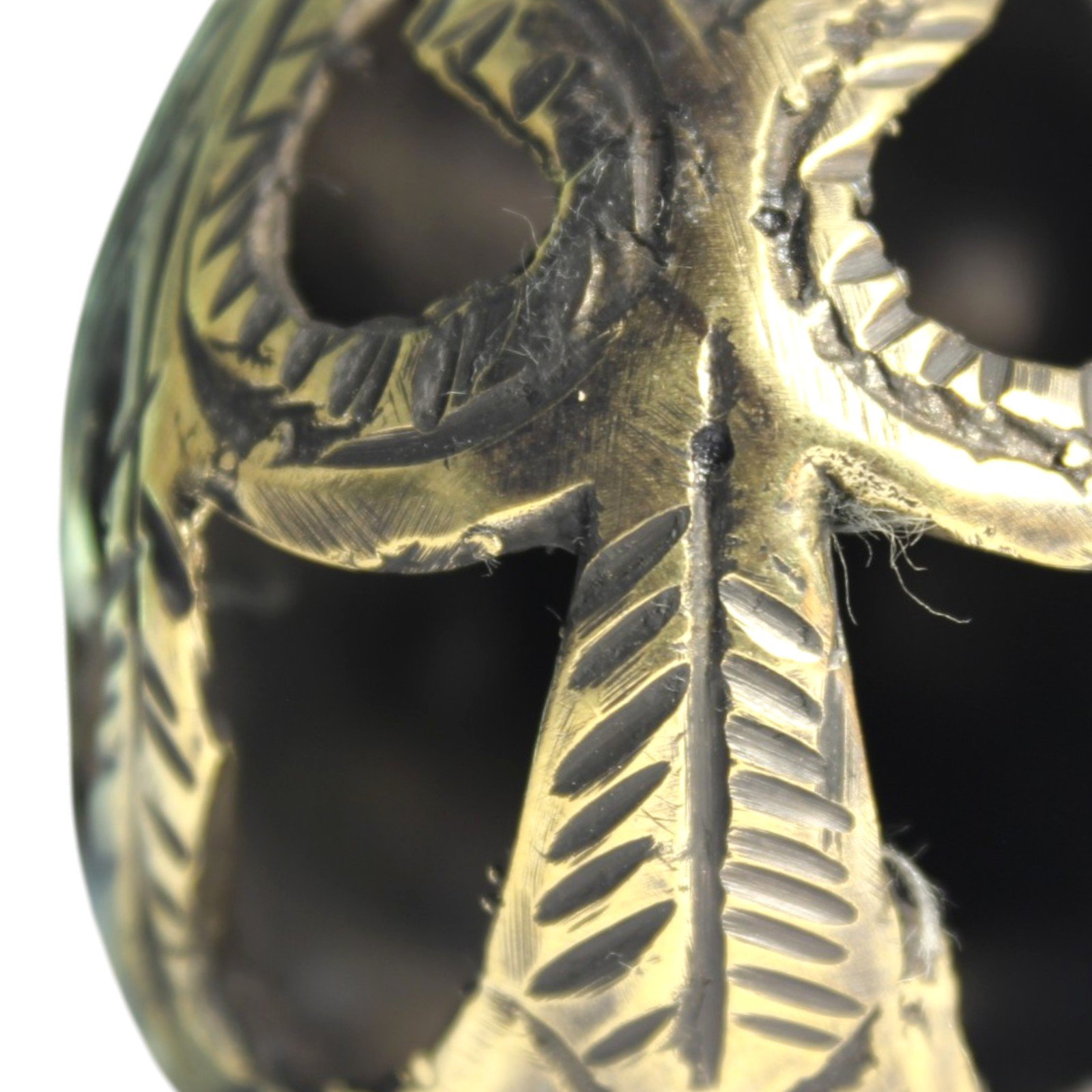 Handvara view of the brass skull figurine showing symmetrical carving and aged finish